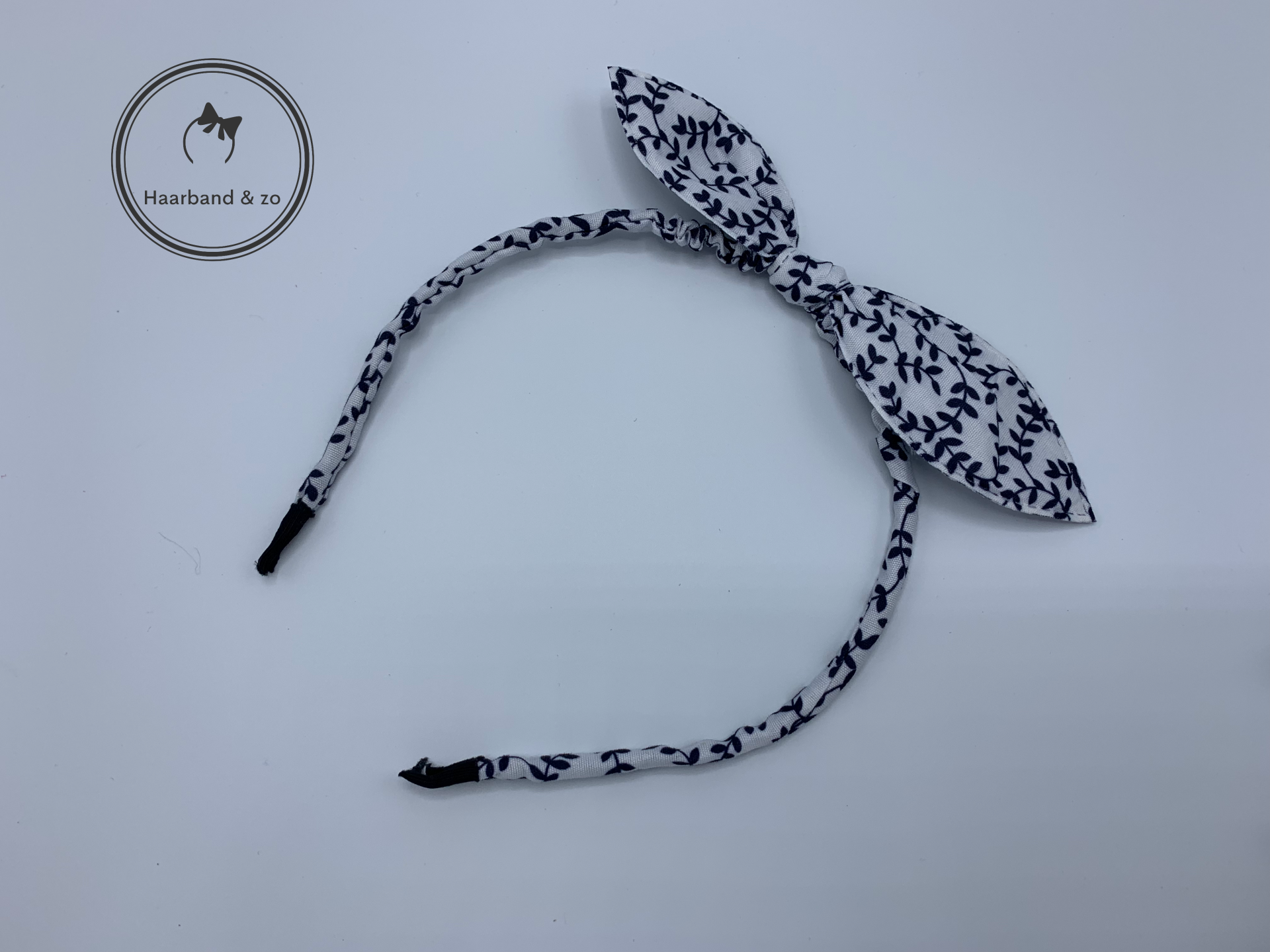 Kinder booghaarband van stof met strik in bloemetjespatroon, wit/donkerblauw (art.nr. 17-11)