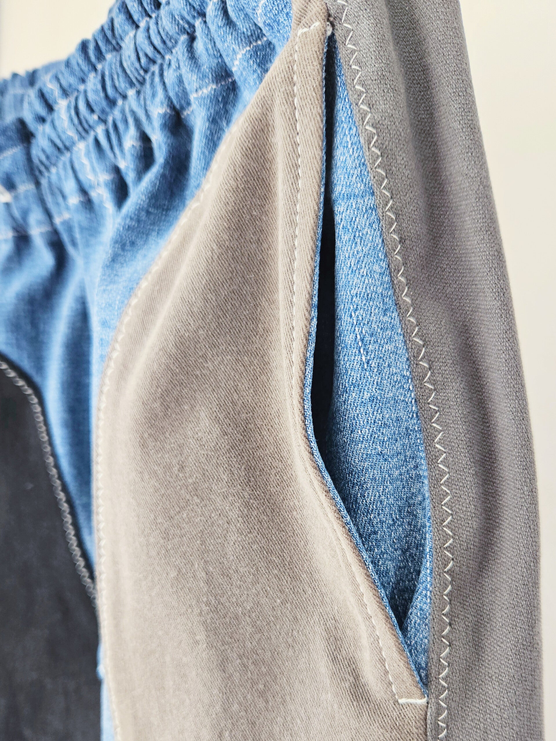 Close-up of stitching and elastic waistband on handmade Trash Trousers from reclaimed jeans.