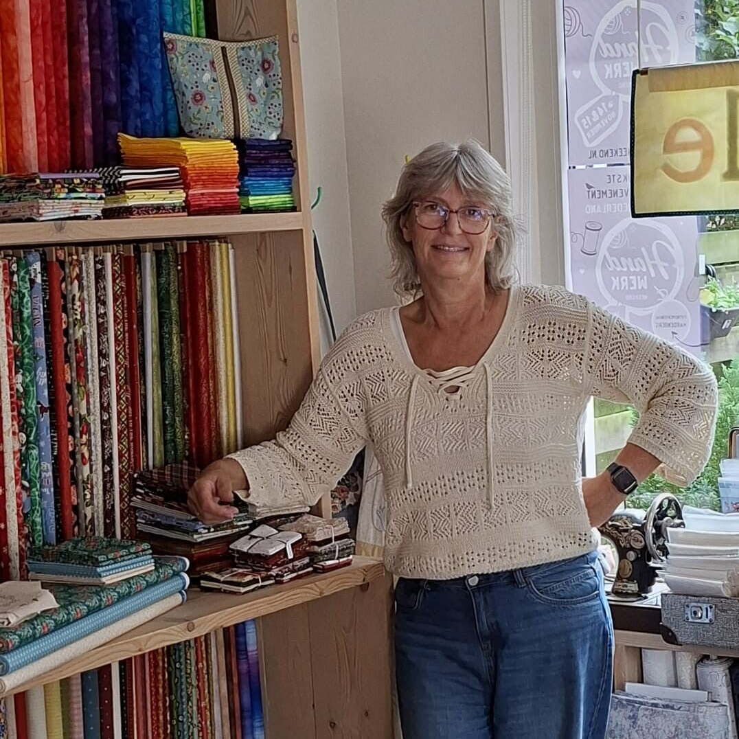 Jantina Snijder, eigenaresse van Qwille, voor de kast met quiltstoffen in de winkel.