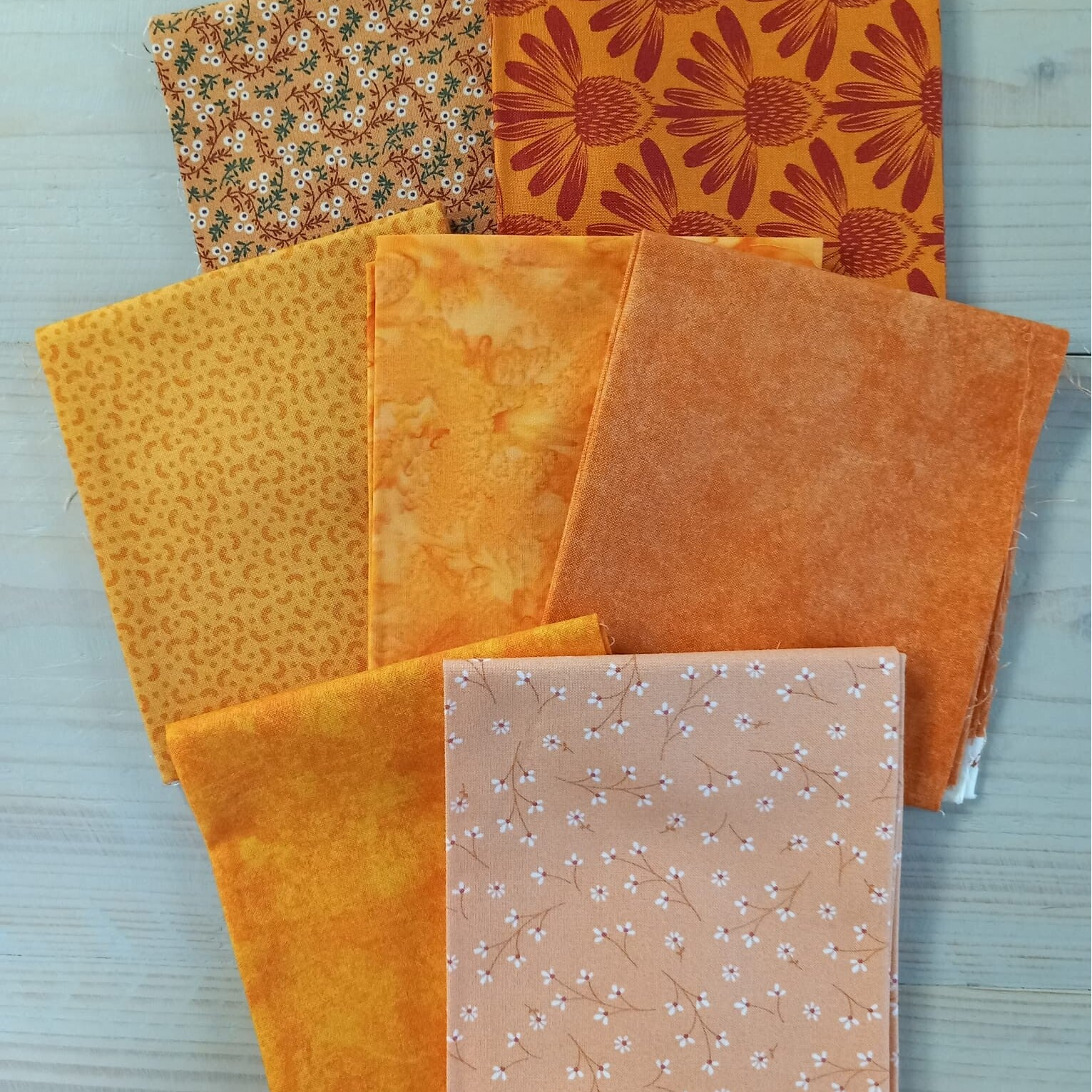 zeven verschillende oranje fat quarters quiltstoffen