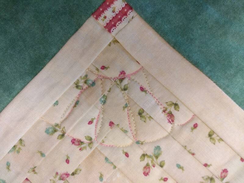 deel van een quilt met witte stof en roze stiksel met de westalee ruler genaaid