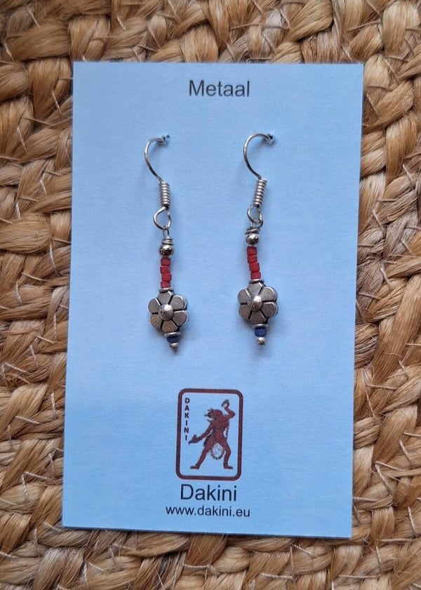 Oorbellen van metaal met oranje kraaltjes en bloem.