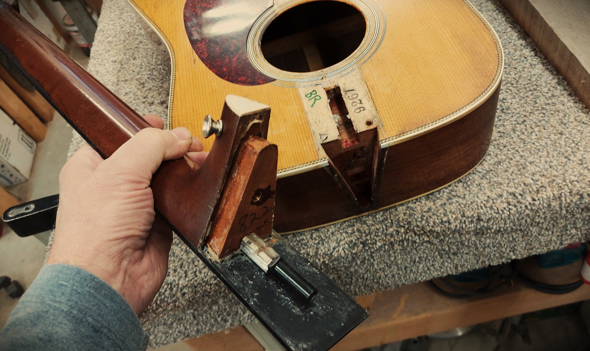 John McQuarrie holding a neck from a MArtin guitar that is at the Northwood shop having a neck reset completed.