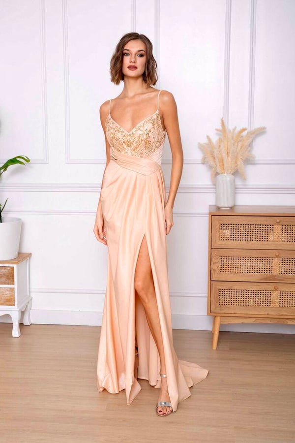 Elegante, lange Galajurk in een zachte perzik kleur met een glanzende, satijnachtige afwerking