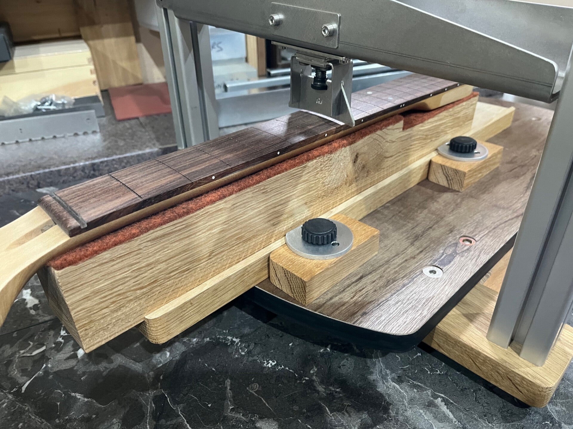GMC Luthier Tools Full Guitar Fret Press with the sliding neck caul upgrade shown pressing a fret at the centre of the neck.