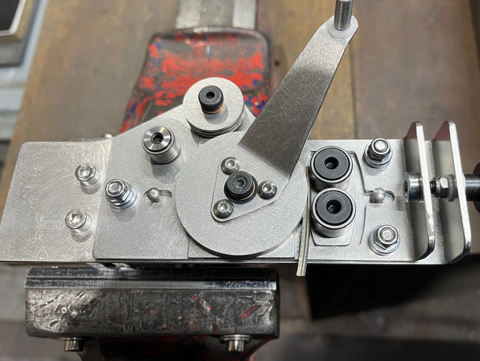 Robust fret bender clamped in a bench vice bending a single uniform radiused fret