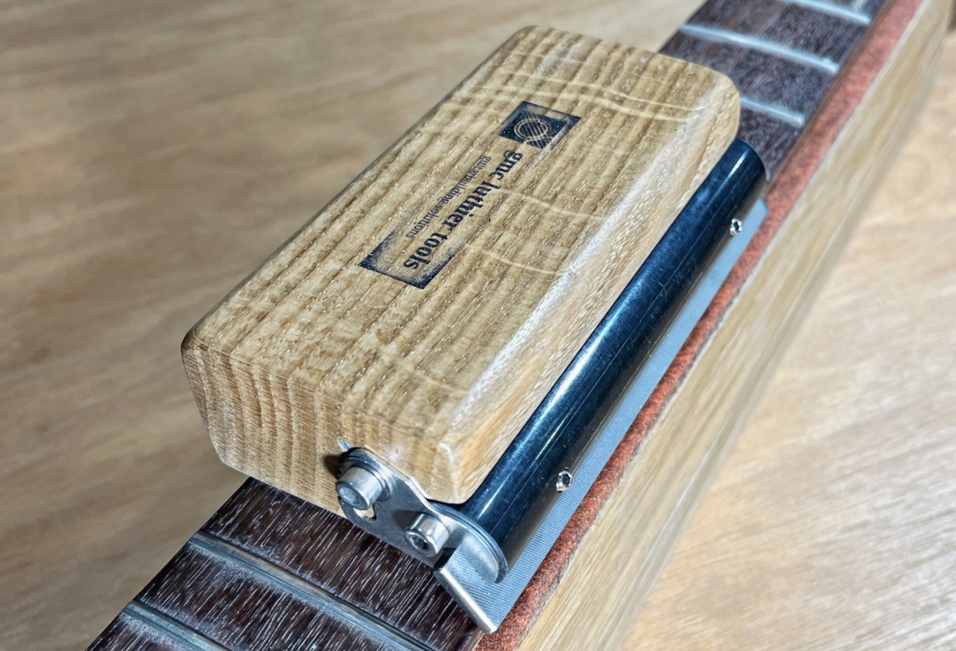 Unique fret end bevel file with angular adjustment bevelling the fret ends on a guitar neck