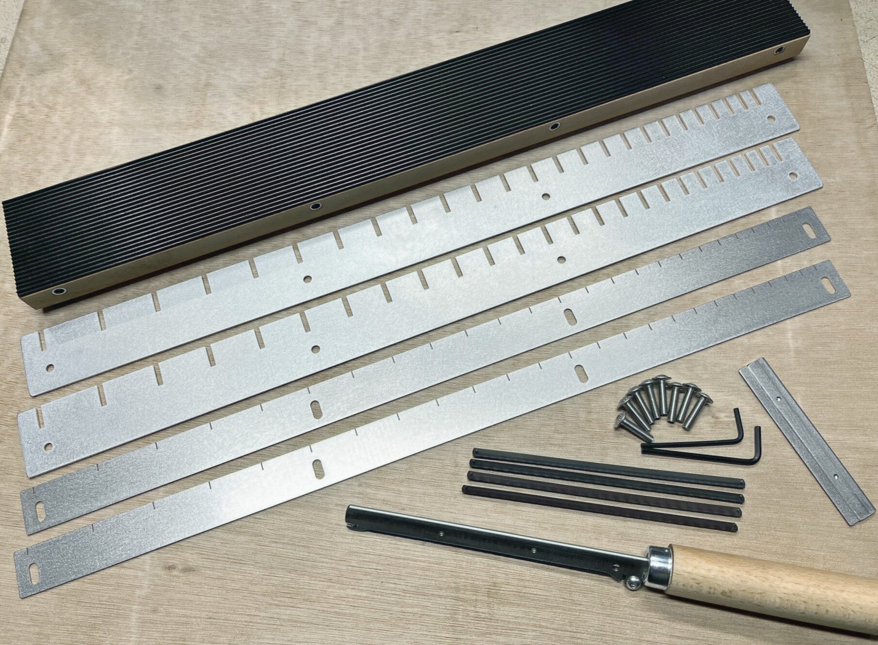 GMC Luthier Tools 'Traditional style' fret slotting jig box laid out on a bench with fret scale templates, fretsaw and spare blades.