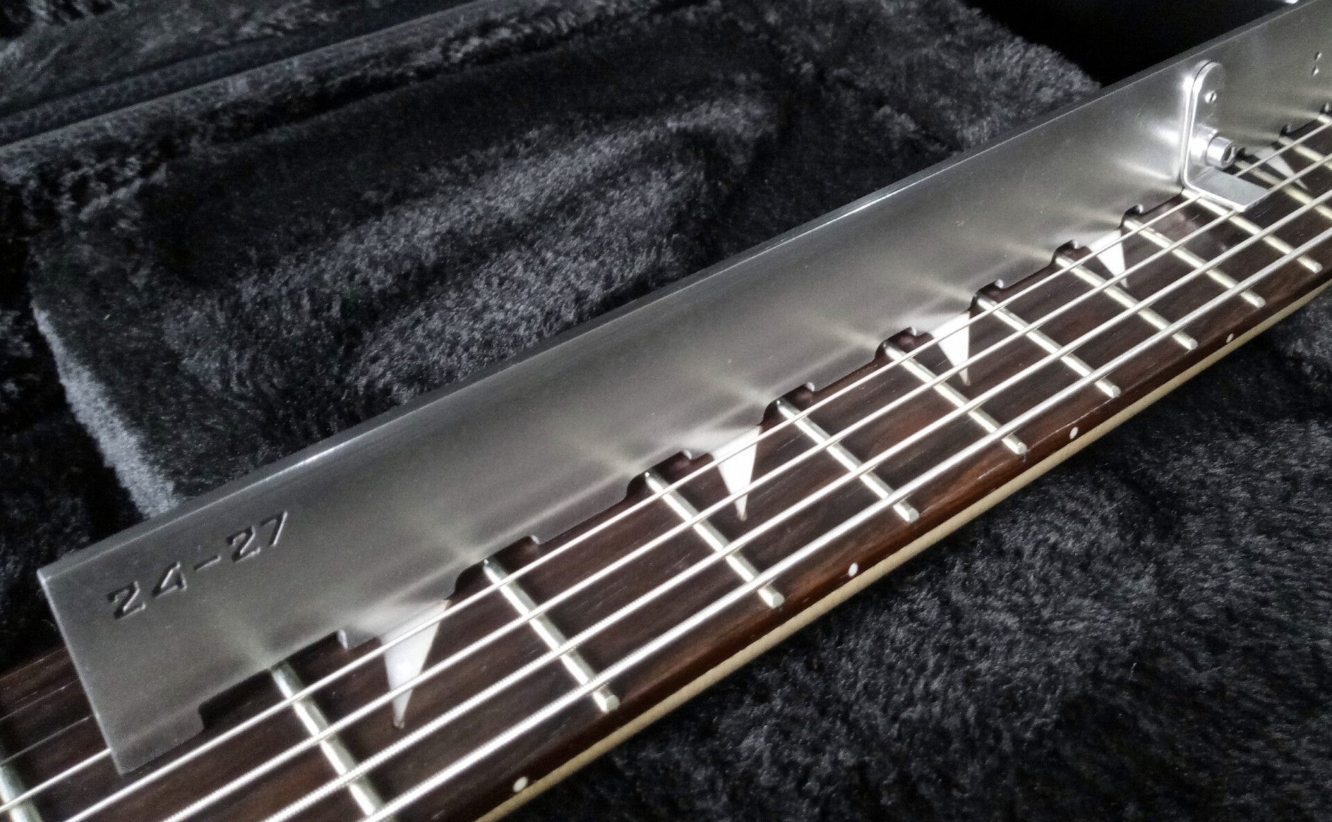 GMC Luthier Tools Universal Notched Edge shown checking an 8-string guitar.