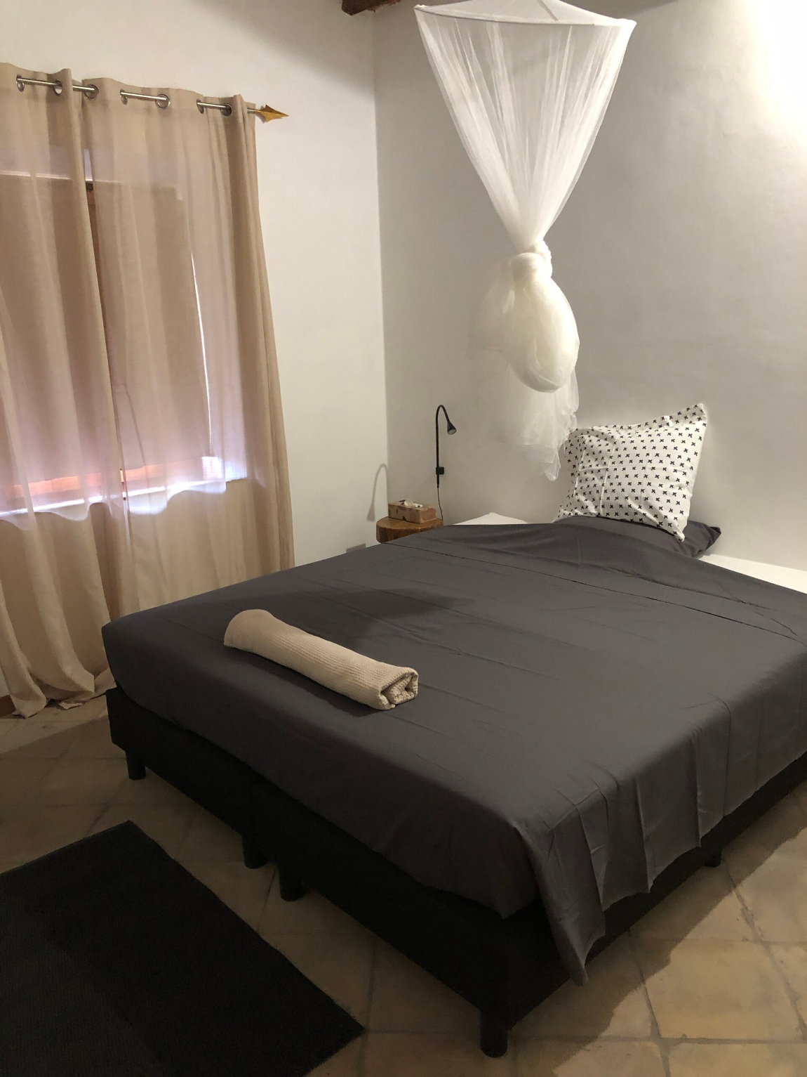 Ruime slaapkamer met airconditioning en muskietennet.