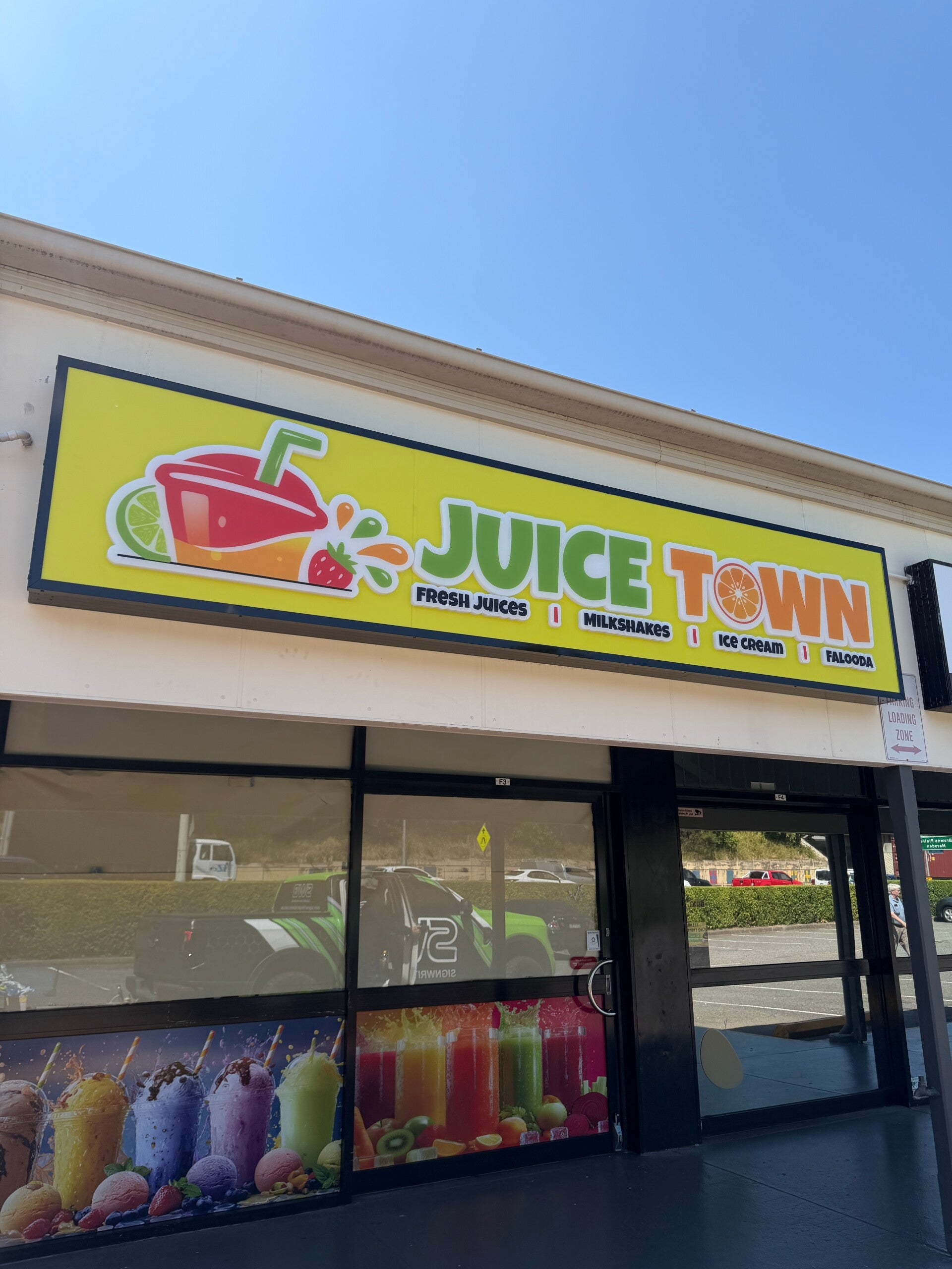 Custom illuminated shopfront lightbox for Juice Town, featuring colorful 3D graphics and retail branding by Brisbane signwriters.