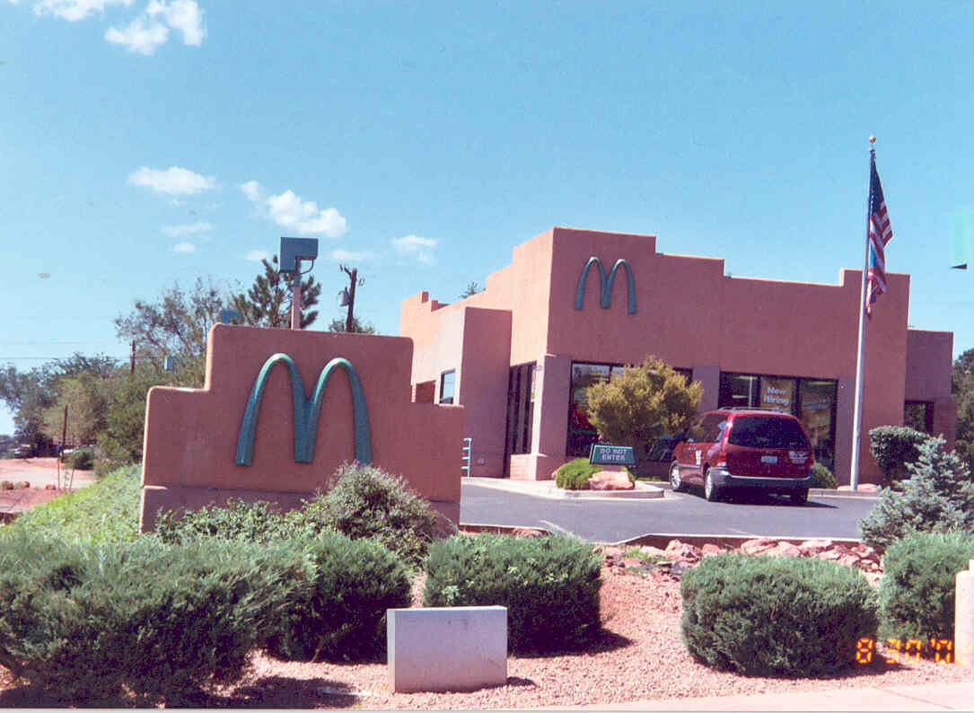 Alt= Vue de la devanture du McDonald's de Sedona avec ses arches turquoise et les roches rouges en arrière-plan