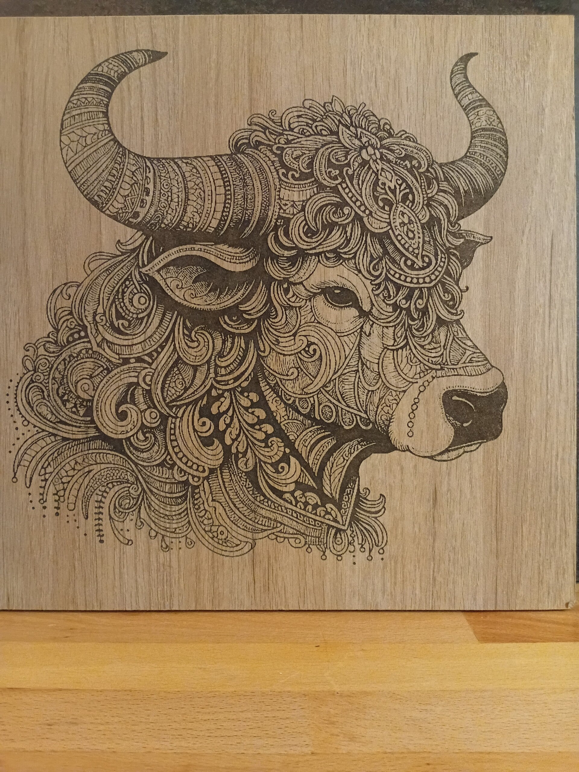 Gravure d'une vache sur planche en fibre de bois
