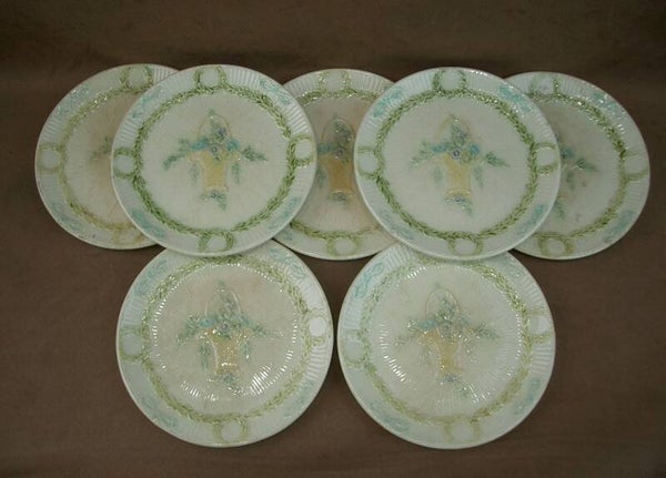 Suite de 7 assiettes anciennes en barbotine à décor de panier de fleurs