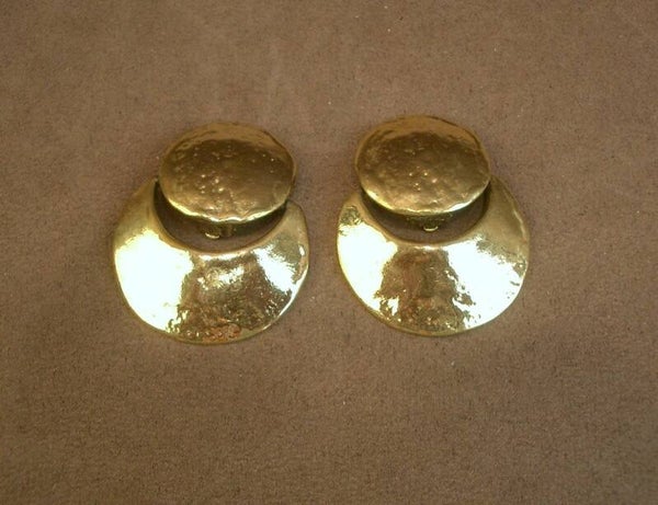 Paire de clips vintage en métal doré martelé signés Yves Saint Laurent