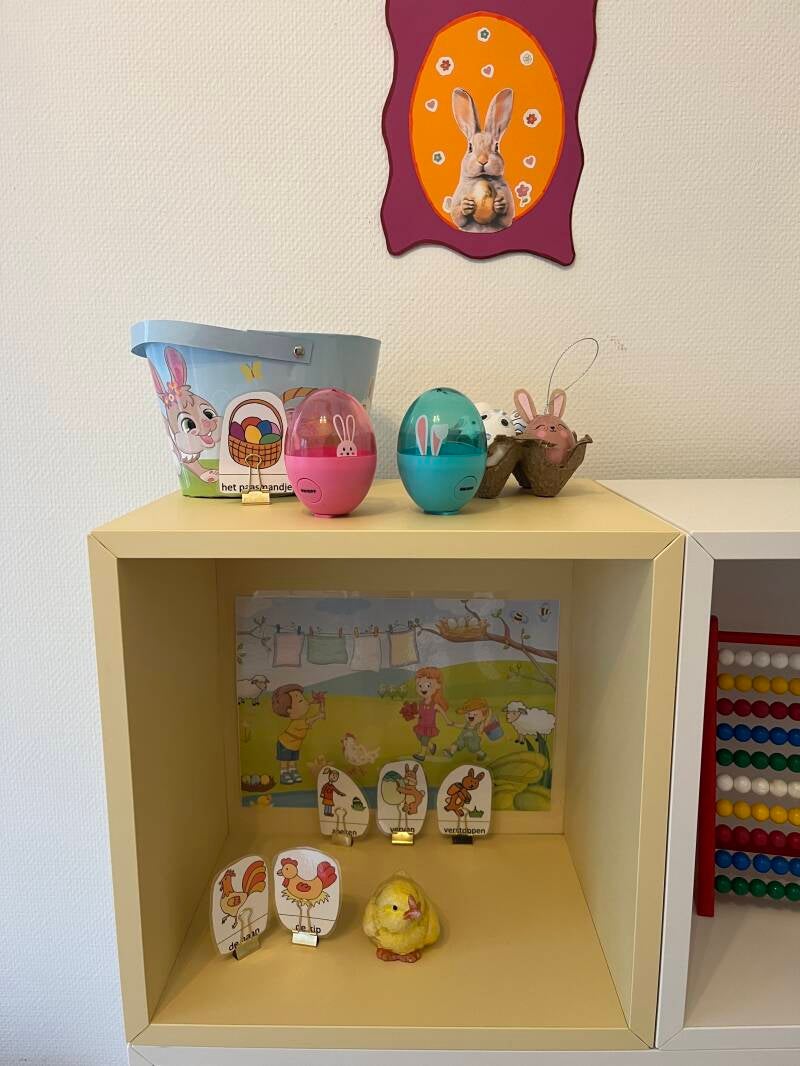 Foto van een kast met voorwerpen en woordkaarten in het thema Pasen. In de therapieruimte bij Kinderlogopedie Reinders in Arnhem.