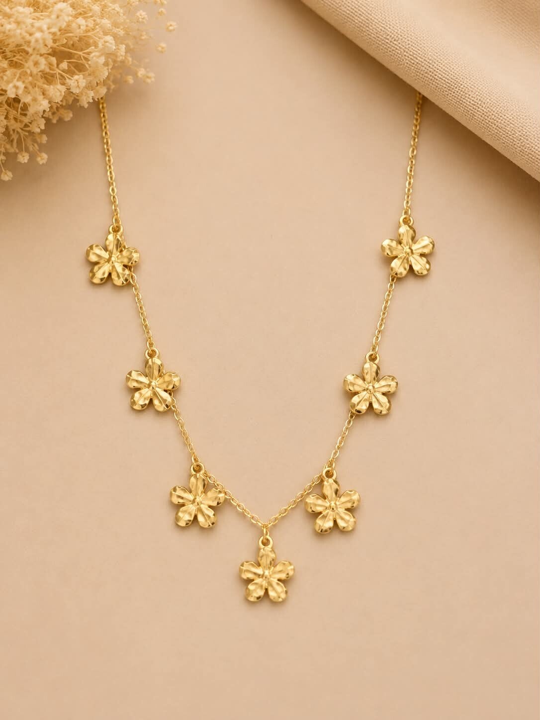Collier orné de sept fleurs martelées Doré
