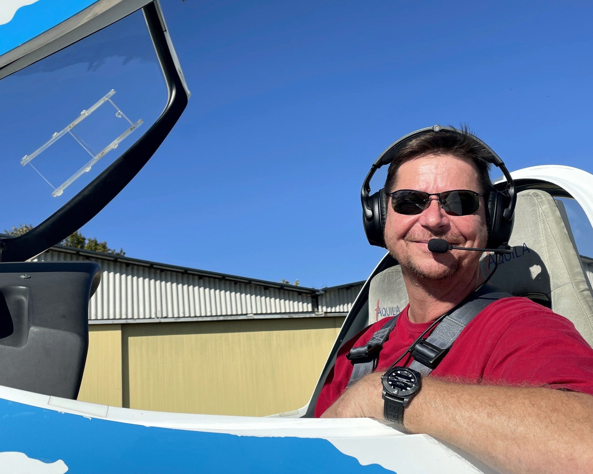 Pilot im Flugzeug vor dem Hangar – erfahrene Miky Airlines‑Crew, die Gästen ein sicheres und herzliches Flugerlebnis bietet