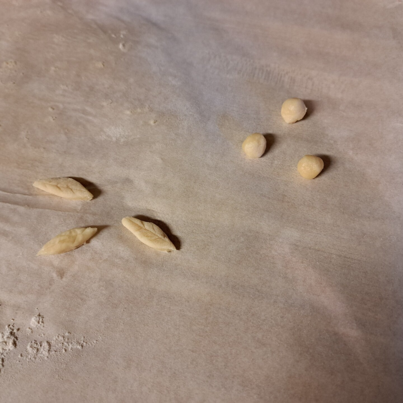 pieces of dough shaped like blueberries and leaves for decoration