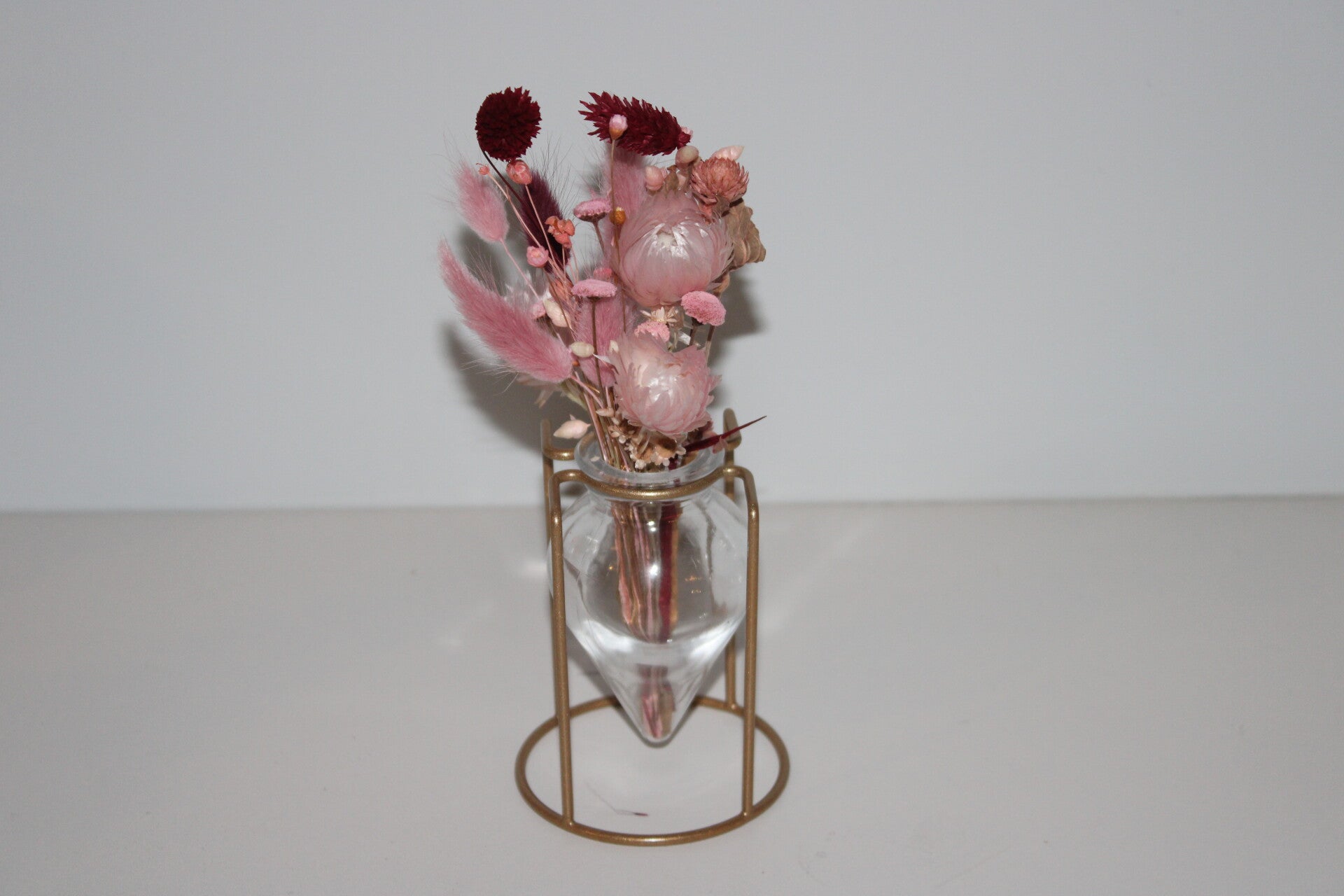 Klein vaasje op staander met droogbloemen