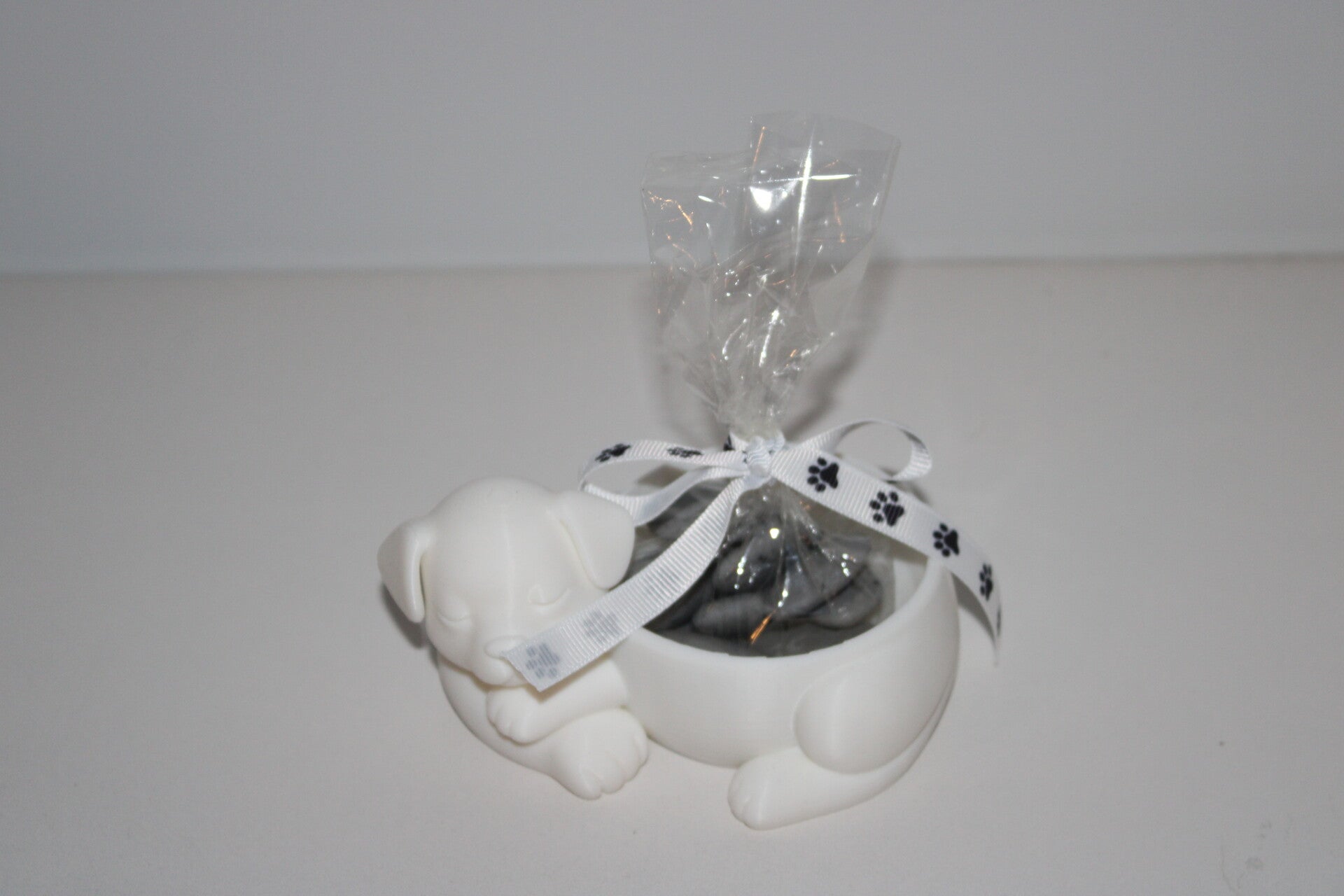 Collectie hond - wit snoeppotje gevuld met donker grijze suikerbonen