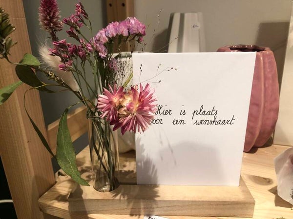 Houten latje met proefbuisje en droogbloemen