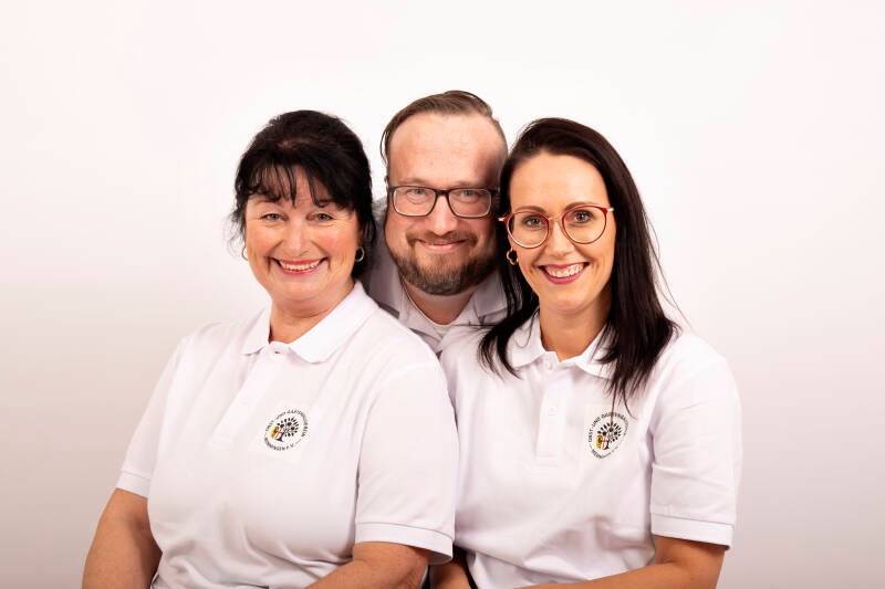 Die gesamte Vorstandschaft des OGV Memmingen sitzend auf einem Bild von Anika Enge - Wedding & Portrait Photography.