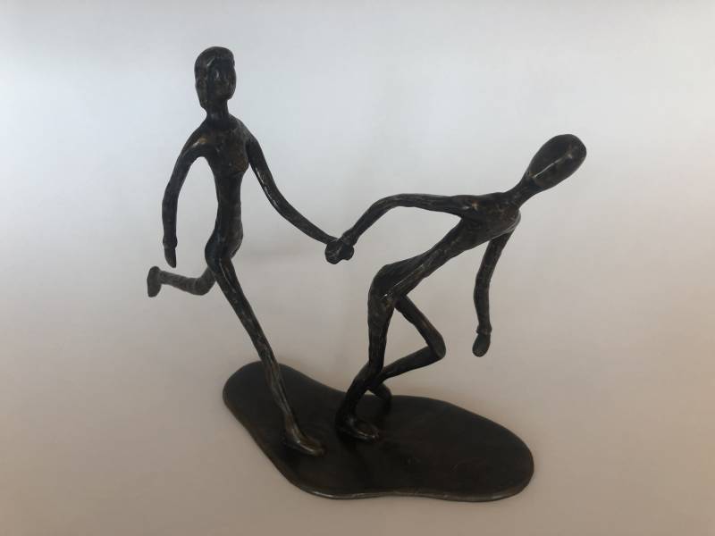 Blinde vrouw hardlopend met buddy in brons door Marius Verhagen