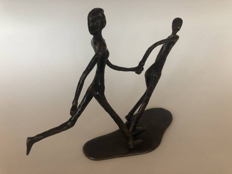 Blinde vrouw hardlopend met buddy in brons door Marius Verhagen