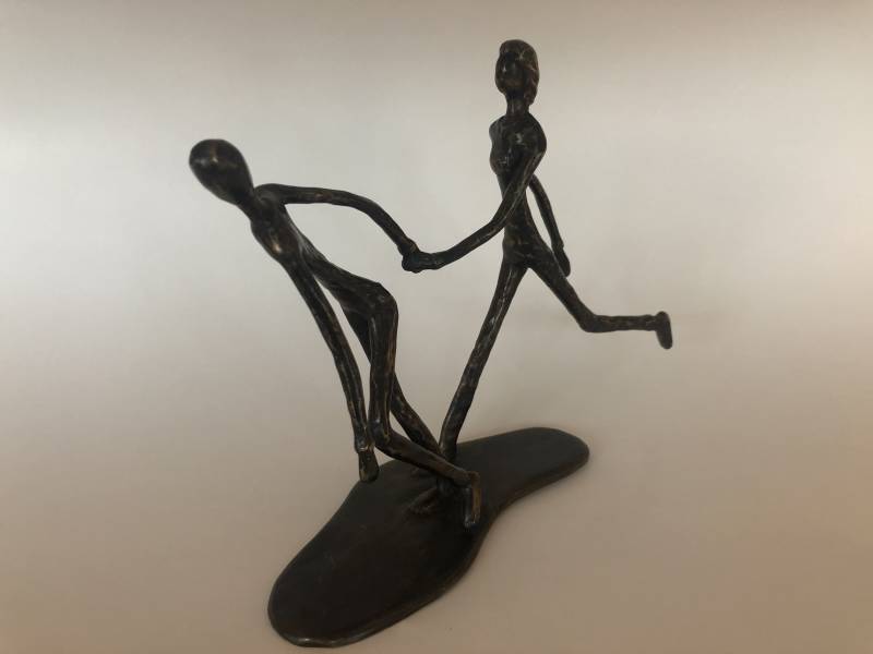 Blinde vrouw hardlopend met buddy in brons door Marius Verhagen