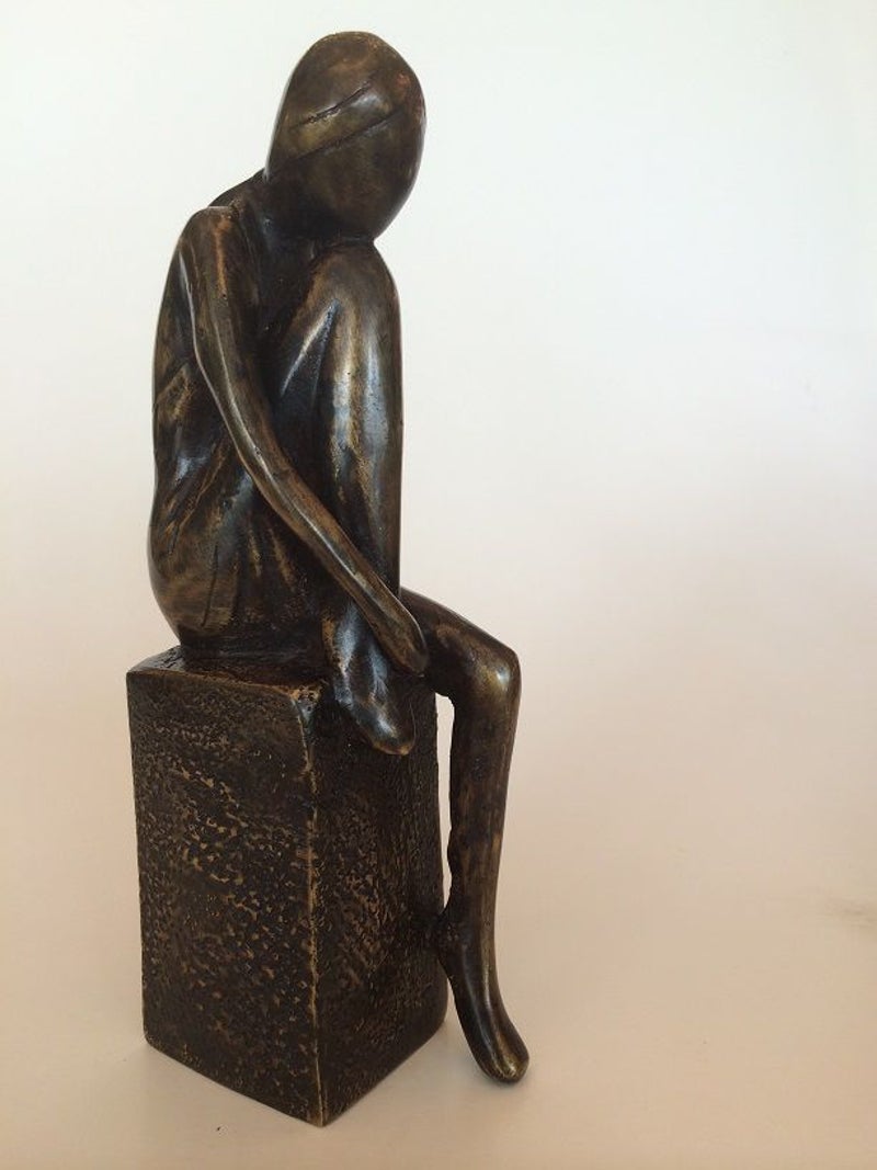 Dit bronzen beeld van de beeldend kunstenaar Marius Verhagen roept onmiddellijk een beeld van herkenning op.  Licht abstract gestileerde jonge vrouw zittend op bronzen sokkel met opgetrokken been.