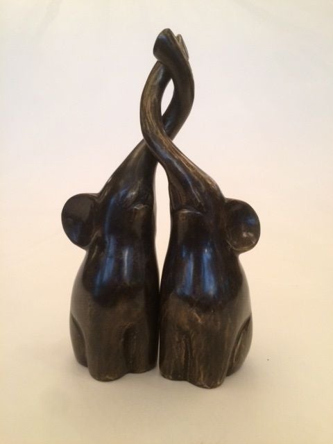 Bronzen beeldjes van verliefde olifanten met de slurfen in elkaar gekruld