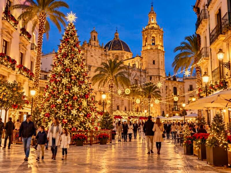 Kerst in Spanje met een versierde kerstboom, palmbomen en feestelijke verlichting op een Spaans plein.