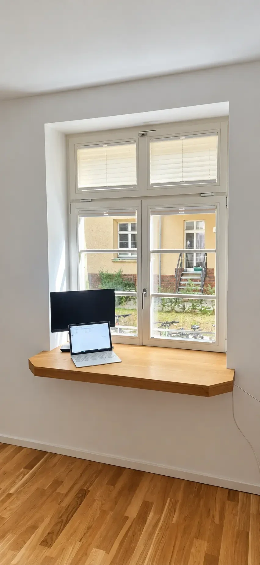 Maßgefertigter Arbeitsplatz aus geölter Eiche, passgenau in eine Fensternische integriert