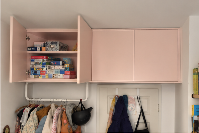 Geöffneter rosa Deckenschrank nach Maß mit sichtbarer Innenaufteilung.
