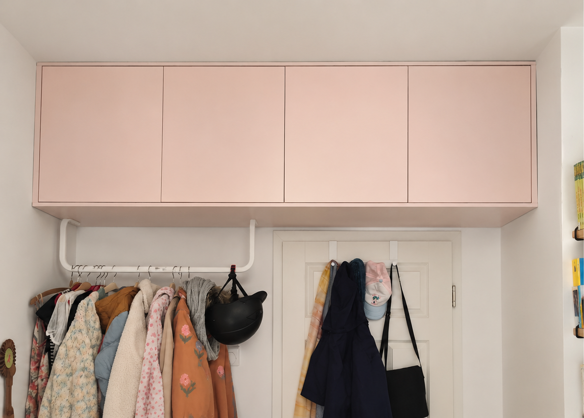 Maßgefertigter rosa Deckenschrank über einer Tür mit flächenbündigen Fronten.