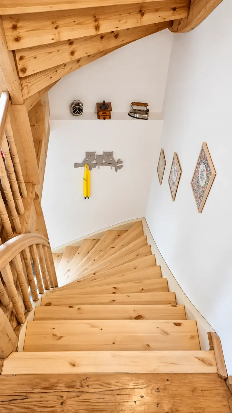 Blick von oben auf eine Fichtentreppe mit individuell nach Schablonen gefertigten neuen Trittstufen im gewendelten Bereich.