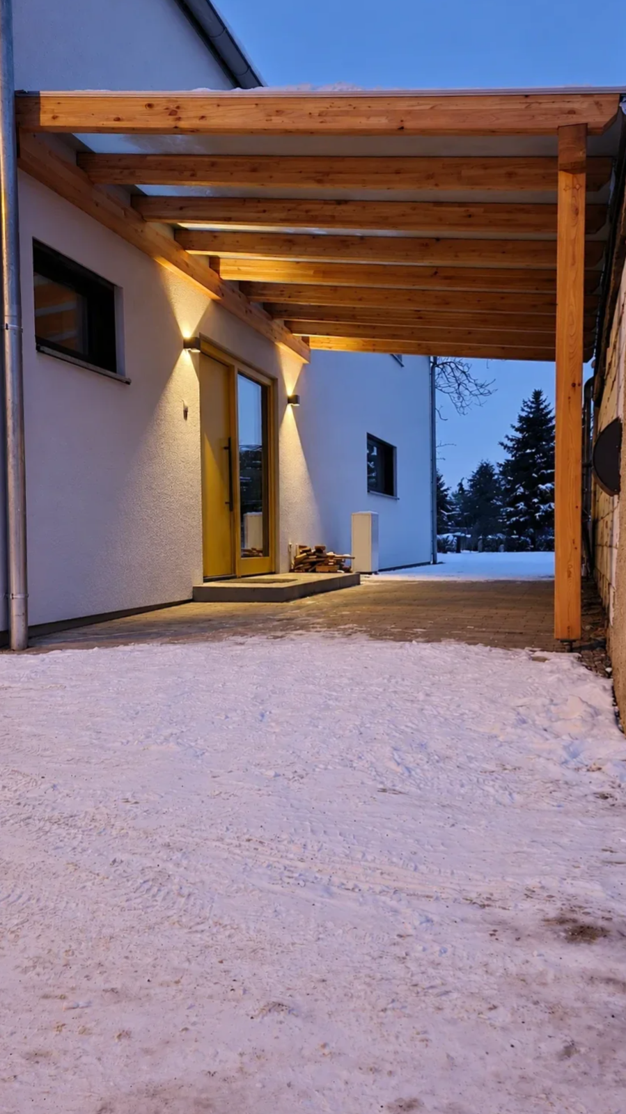Auch bei Schnee und in den Abendstunden bietet die Überdachung einen geschützten, gut nutzbaren Zugang zum Gebäude.