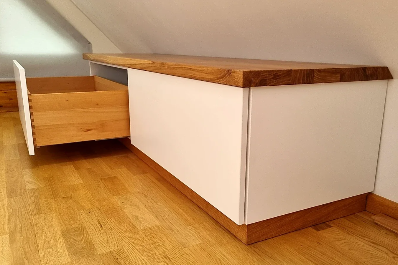 Geöffnete fingergezinkte Eichenschublade einer maßgefertigten Schlafzimmer-Kommode mit weißem Korpus