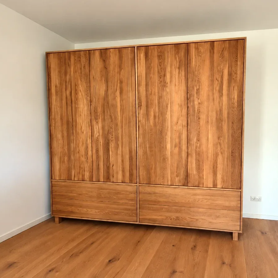 Maßgefertigter Kleiderschrank aus Eiche in einem hellen Schlafzimmer, mit klaren Fronten und warmem Holzbild.