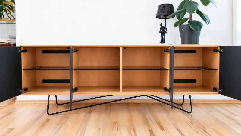 Geöffnetes Lowboard aus Erle mit Glasfächern und integrierten Luftauslässen mit Staubgitter für Multimedia-Geräte