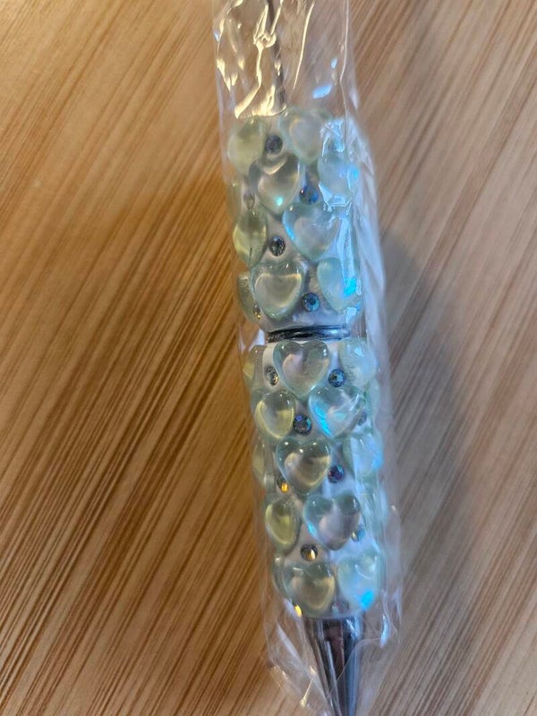 Vit penna med ljus gröna hjärtan
