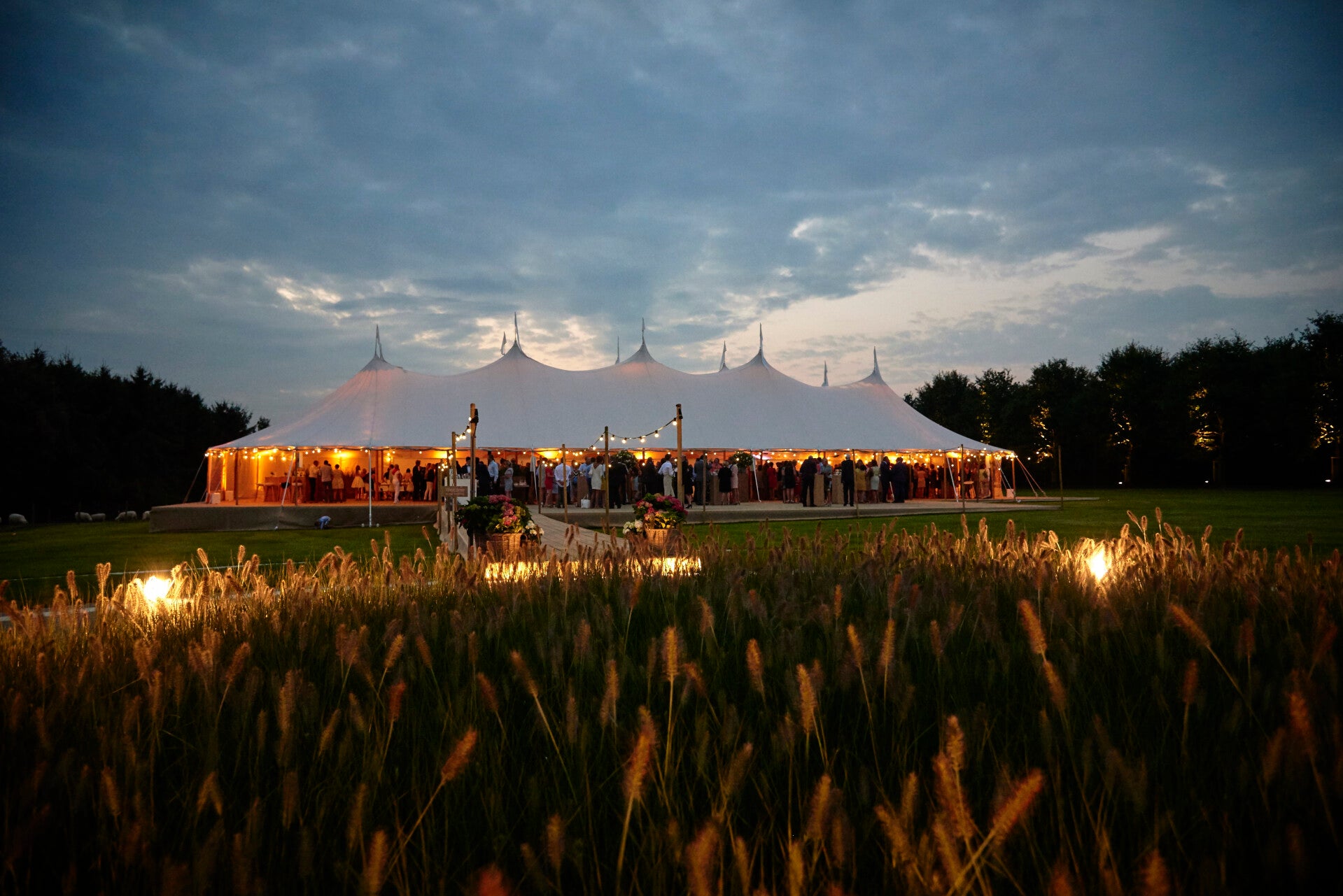 Luxe silhouettetent huren voor bruiloft of evenement, stijlvolle tentoverkapping met houten palen, hoge pieken en sfeervolle uitstraling