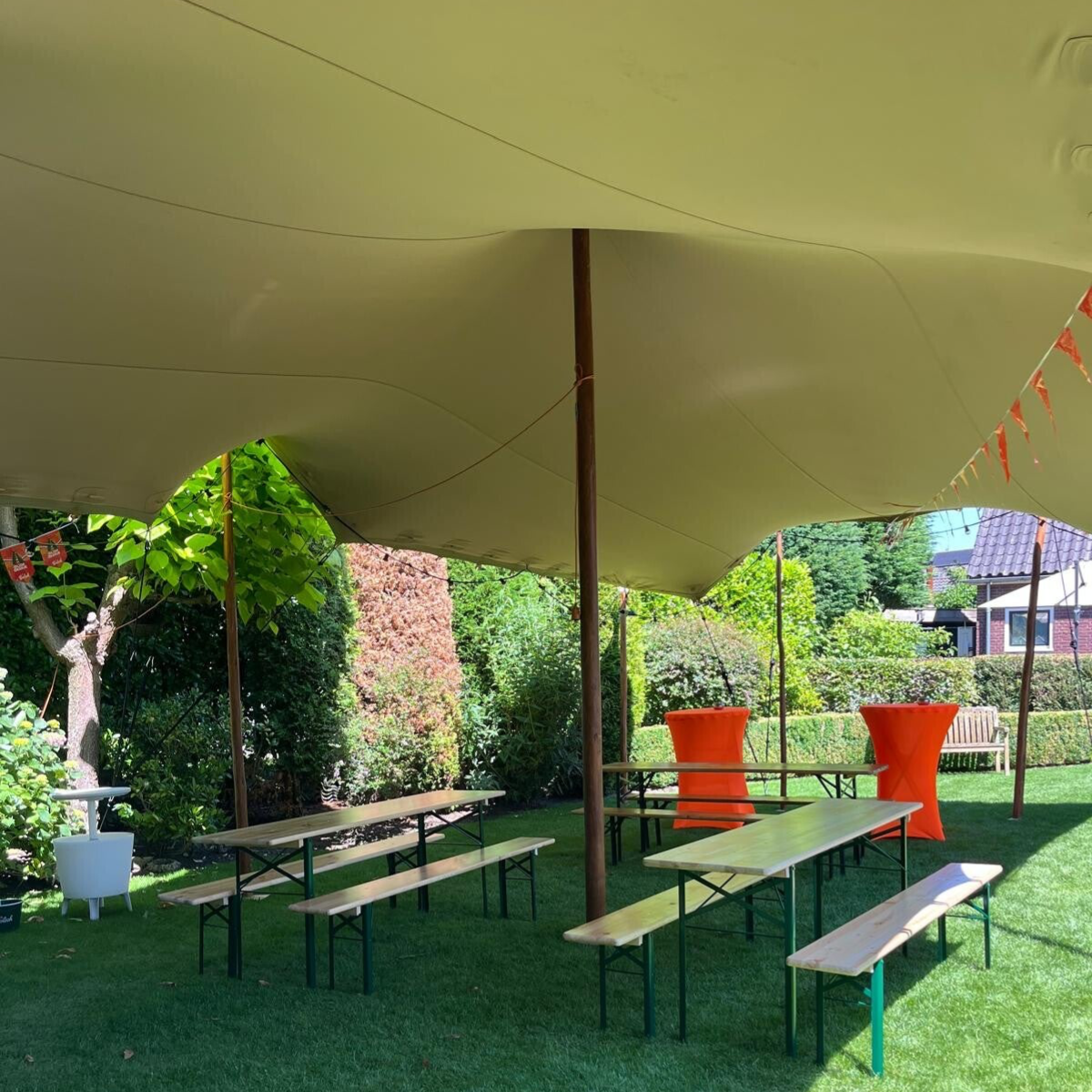 sta tafels en eettafels met banken onder stretchtent met versiering