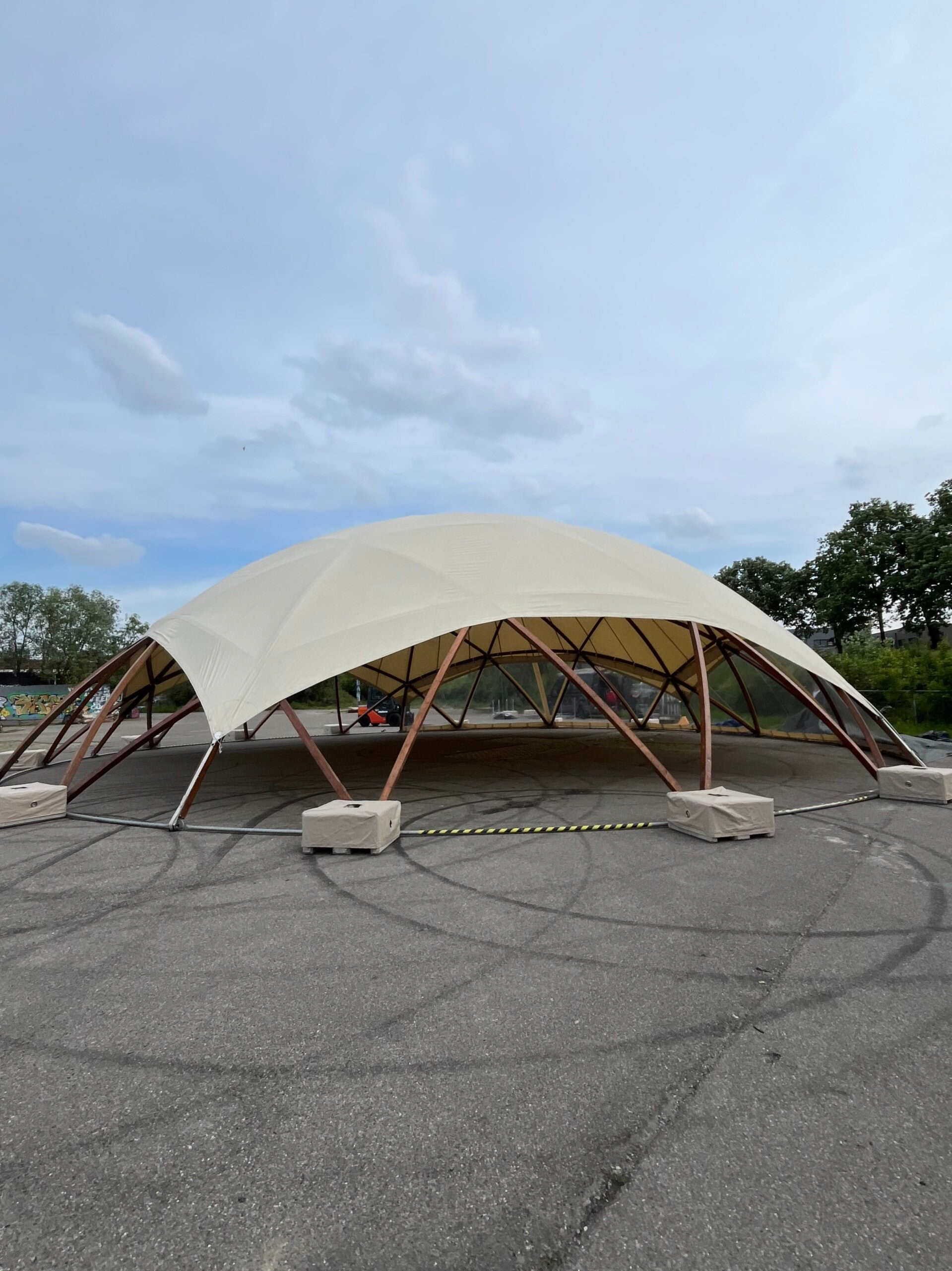 Wooden Flat Dome van 20 meter met wit zeildoek en houten koepelconstructie op festivalterrein in Nijmegen