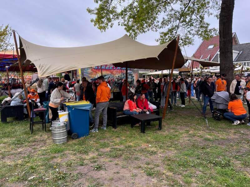 tent met bar en oranje fans onder tent bij hof van huizen