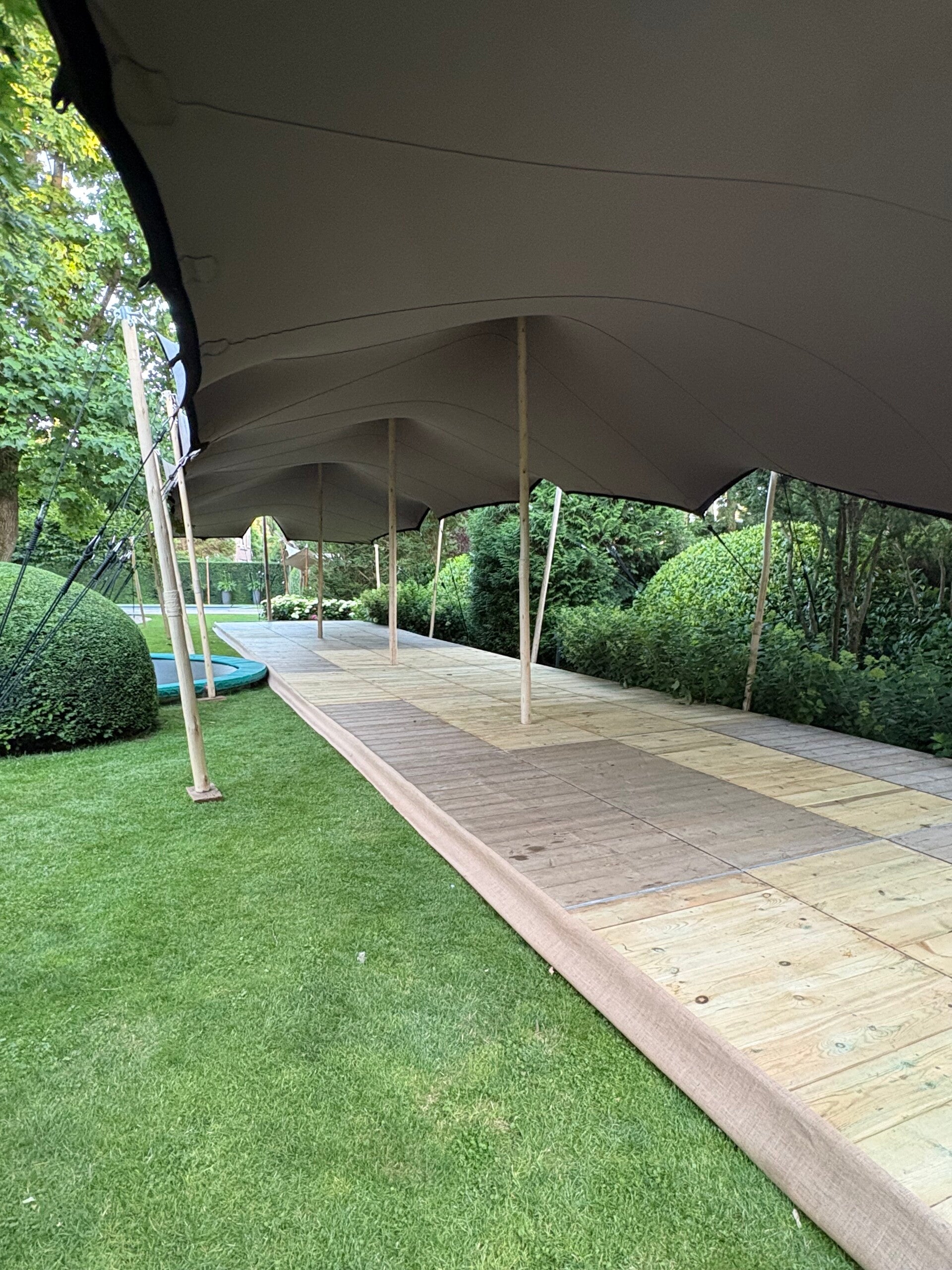 Stretchtent met houten palen en houten cassette vloer eronder