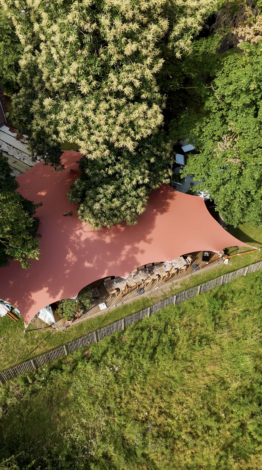 Stetchtent met diner setting onder de tent tussen bomen