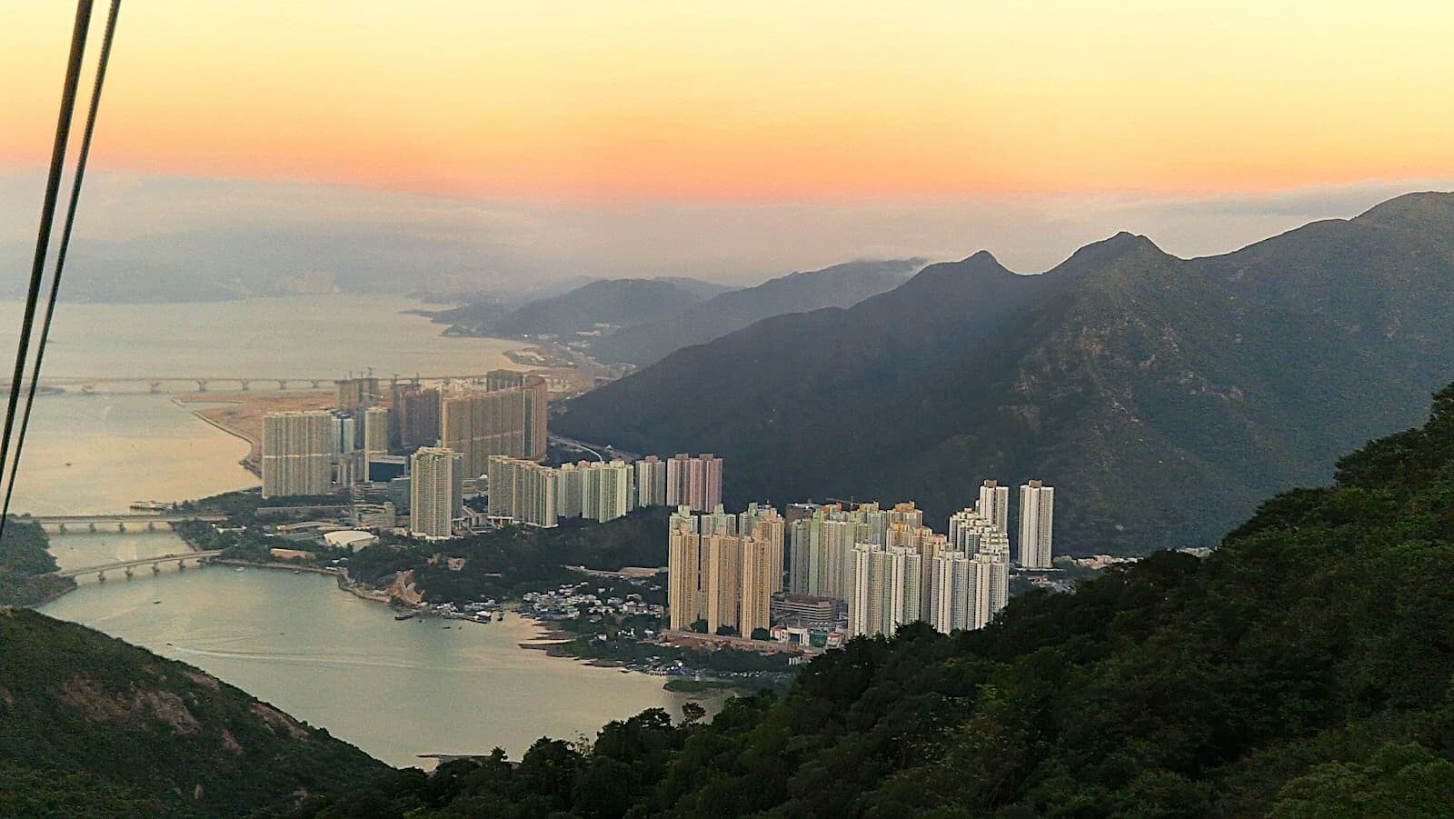 aerial view of skyscrapers between mountains and the sea, representing Reiki for corporate wellness programmes