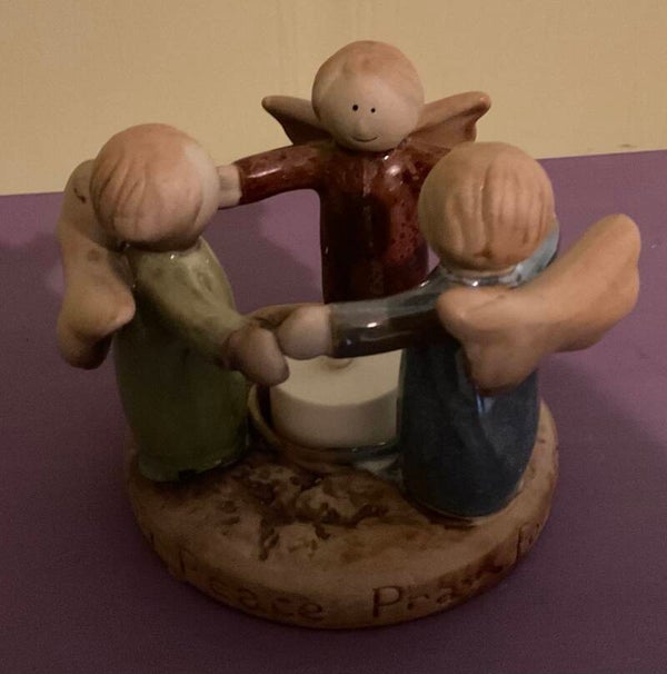 Angels surrounding a votive candle holder